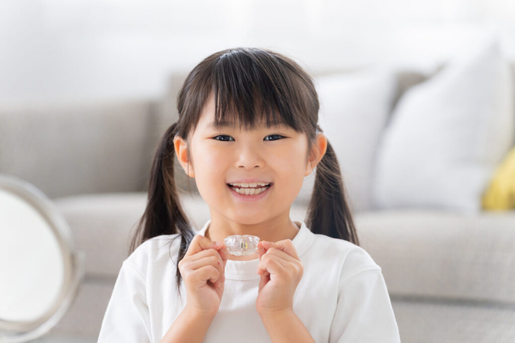 マウスピースで歯列矯正をする子供
