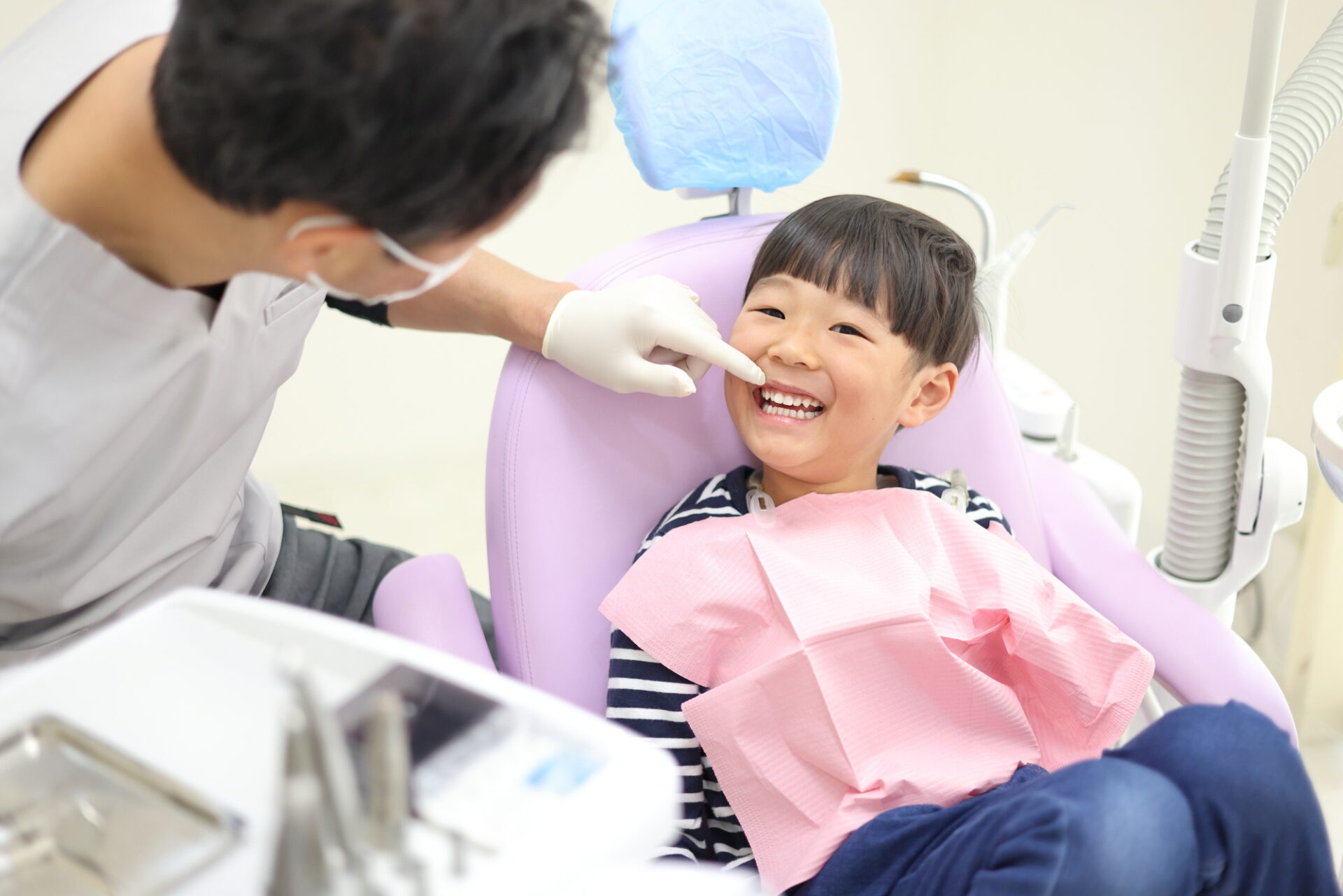 歯科医師が優しく子どものお口を診察している