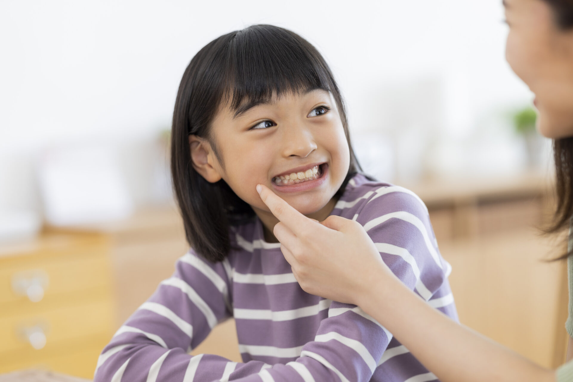 子どもが笑顔で歯を見せている様子
